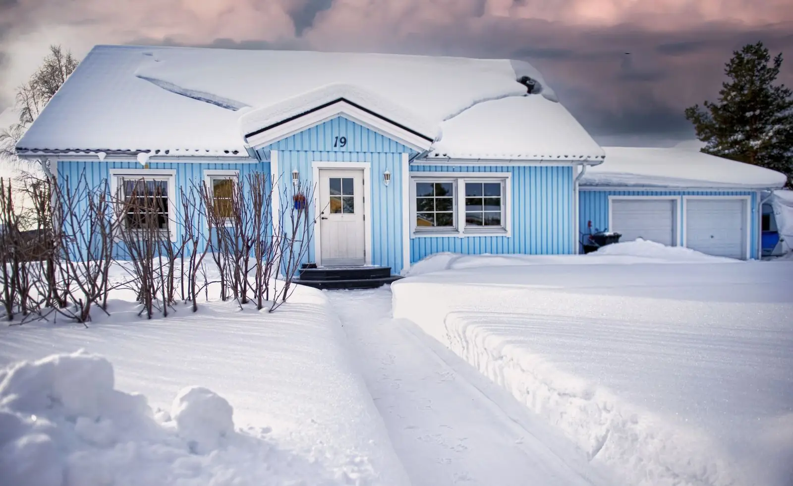 Blue house covered in snow during winter