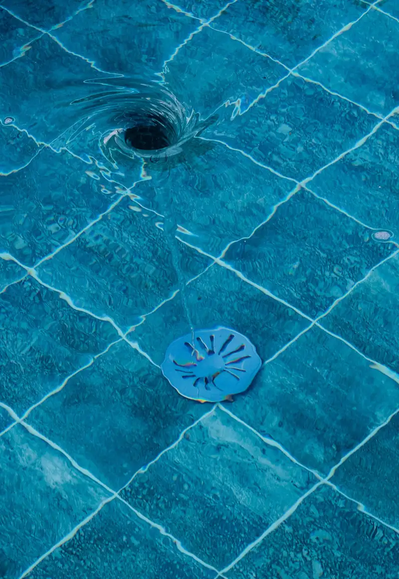 Small round drain cover set in blue tile
